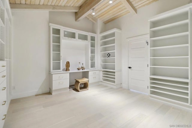 walk in closet featuring light wood-type flooring and vaulted ceiling with beams