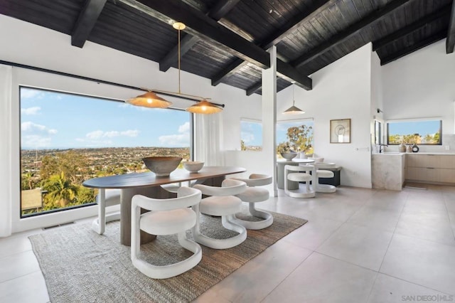 dining area with high vaulted ceiling, beam ceiling, and a wealth of natural light