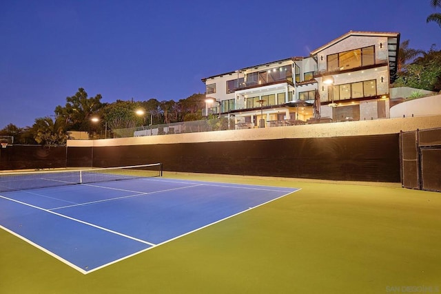 view of tennis court with basketball hoop