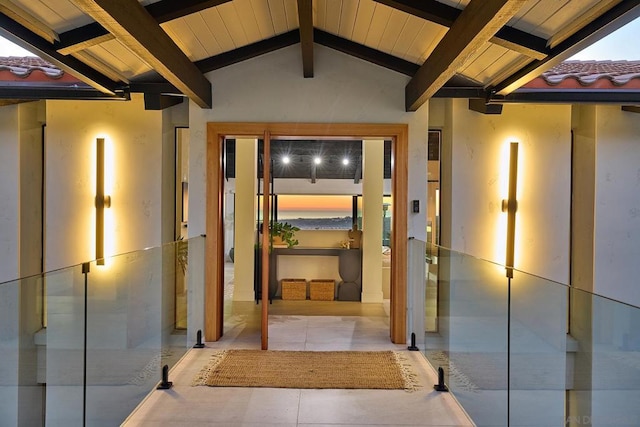 hall with wooden ceiling, a healthy amount of sunlight, and vaulted ceiling with beams