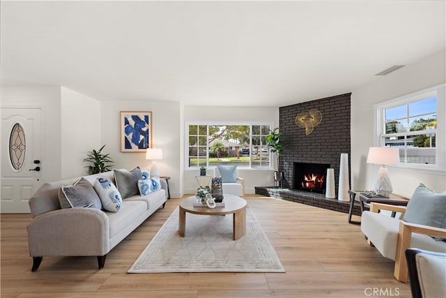 living room featuring light wood-type flooring and a fireplace