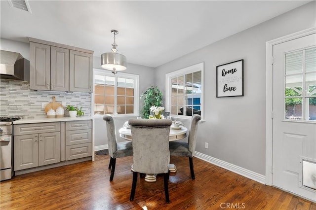 dining area featuring wood finished floors, visible vents, and baseboards