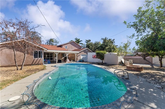 view of pool with a fire pit, a patio area, a fenced backyard, and a fenced in pool