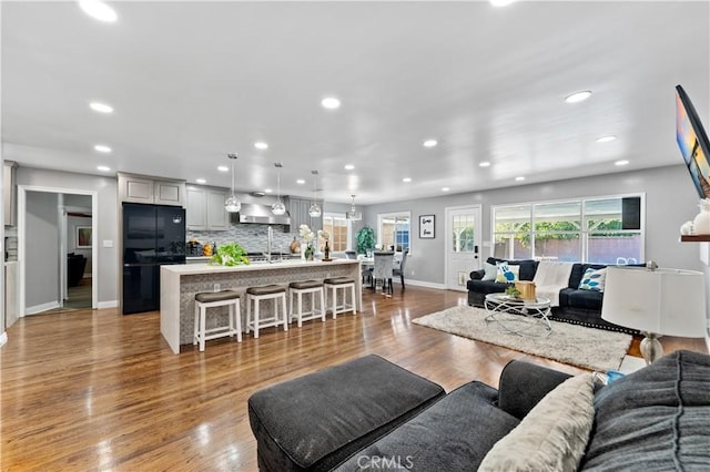 living room featuring recessed lighting, baseboards, and wood finished floors