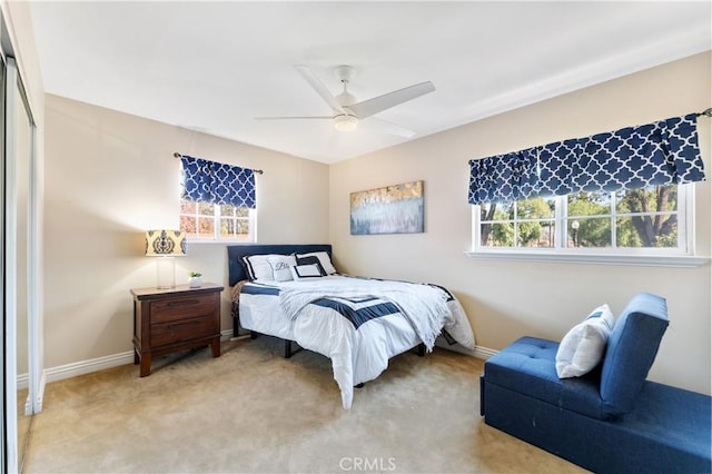 bedroom featuring light carpet, a closet, a ceiling fan, and baseboards