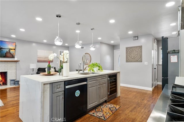 kitchen with wine cooler, dark wood finished floors, gray cabinets, a warm lit fireplace, and dishwasher