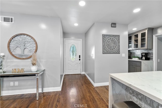 foyer with baseboards, visible vents, dark wood-type flooring, and recessed lighting