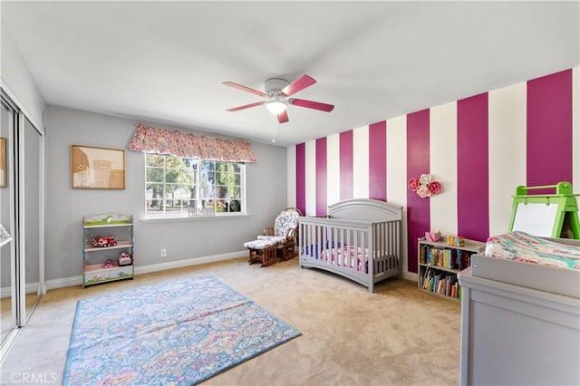 bedroom with wallpapered walls, baseboards, ceiling fan, carpet, and a closet