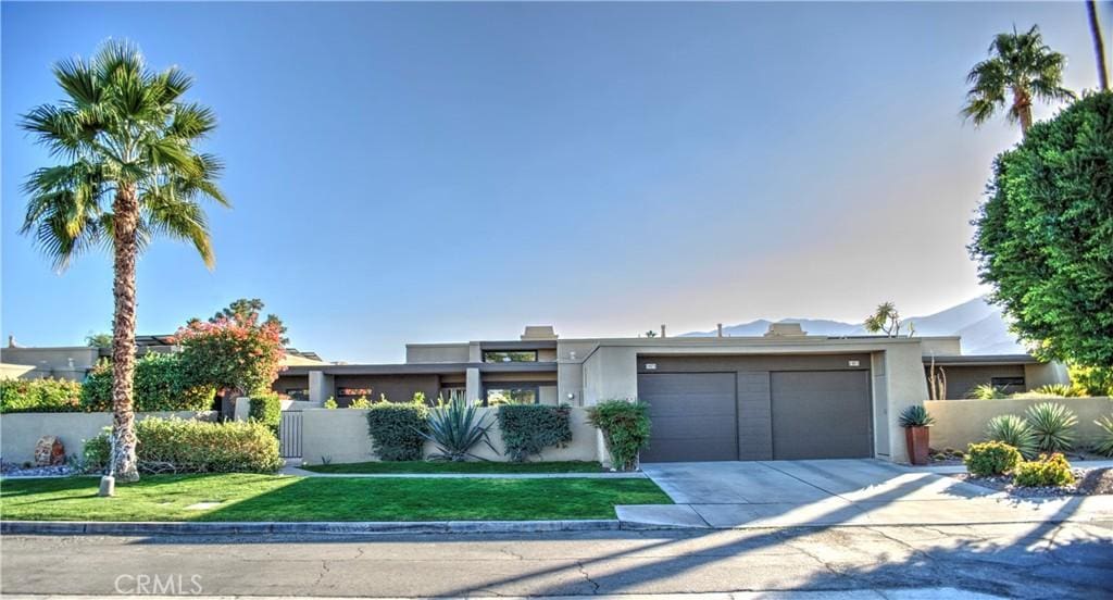 view of front of house with a garage and a front lawn