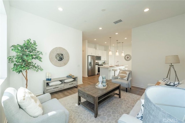 living room with sink and light wood-type flooring