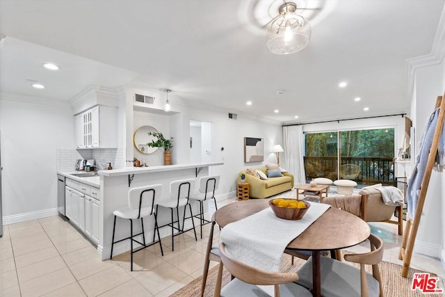 tiled dining space featuring crown molding