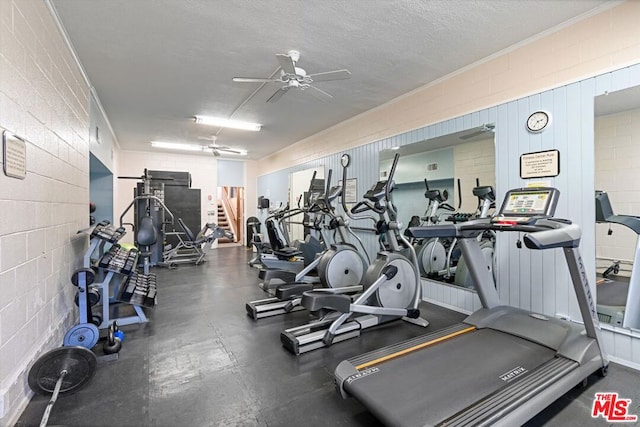 gym with ceiling fan and a textured ceiling