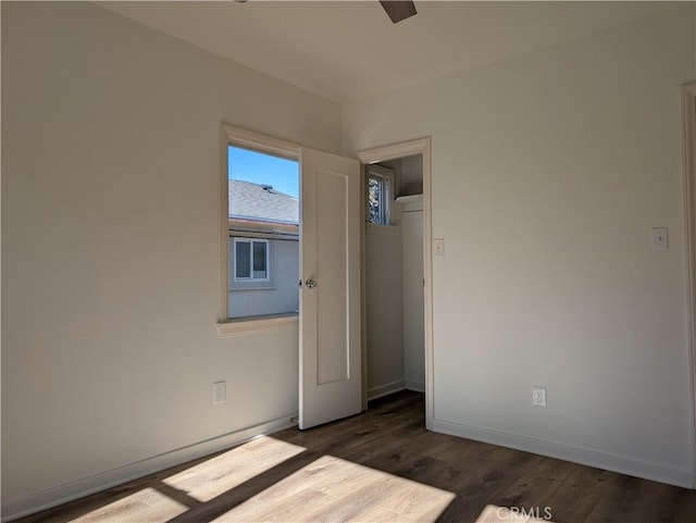 spare room with dark wood finished floors and baseboards