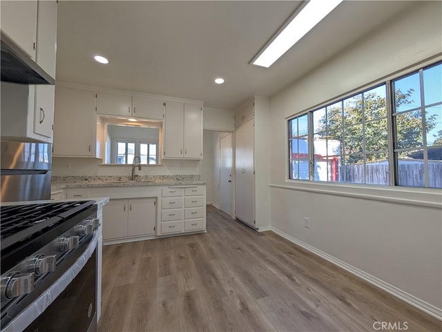 kitchen with appliances with stainless steel finishes, a sink, and white cabinets