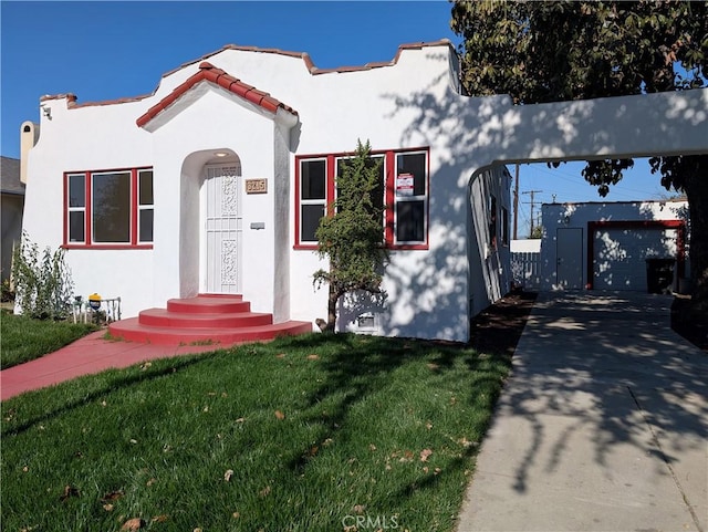 view of front of property with a front yard, a tiled roof, and stucco siding