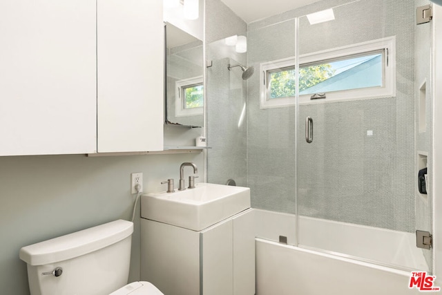 full bathroom featuring shower / bath combination with glass door, vanity, and toilet