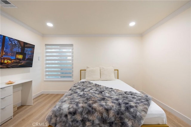 bedroom featuring crown molding and light wood-type flooring