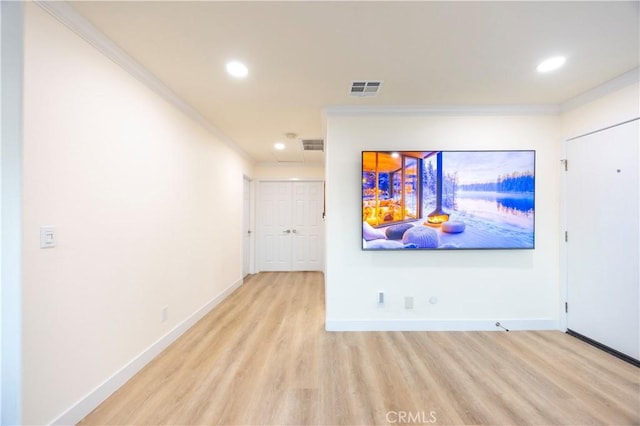 unfurnished living room featuring ornamental molding and light hardwood / wood-style flooring