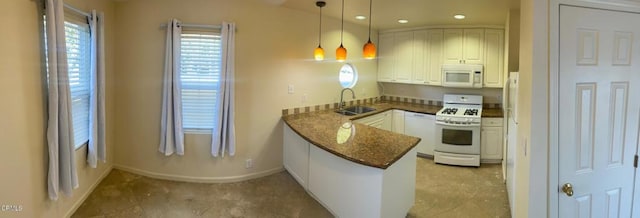 kitchen featuring white appliances, kitchen peninsula, pendant lighting, white cabinets, and sink