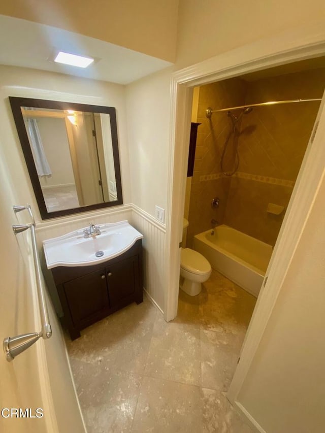 full bathroom featuring toilet, tiled shower / bath combo, and vanity