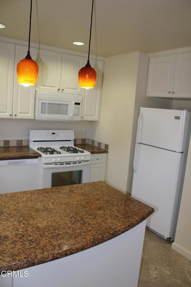 kitchen with white appliances, pendant lighting, and white cabinets