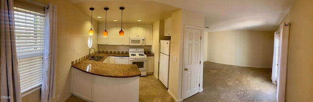 kitchen featuring white appliances, kitchen peninsula, pendant lighting, white cabinets, and sink