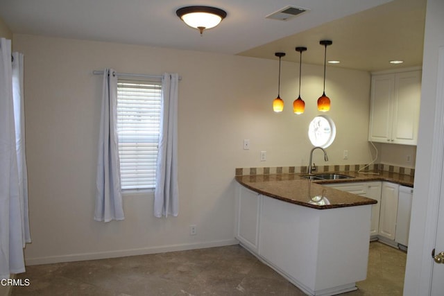 kitchen with sink, white cabinetry, pendant lighting, and kitchen peninsula