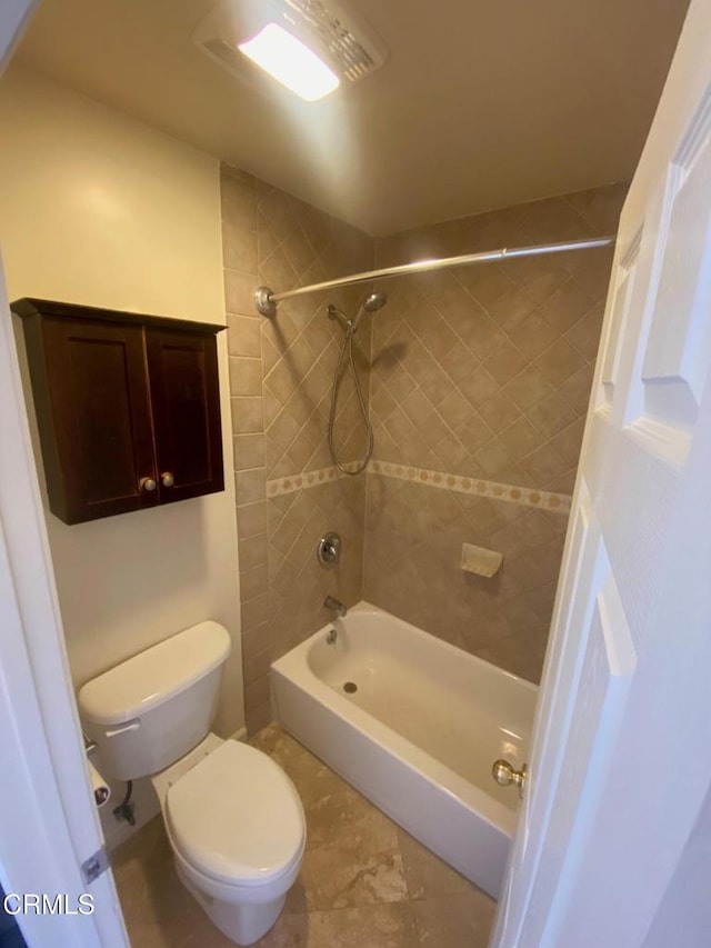 bathroom with tiled shower / bath combo and toilet