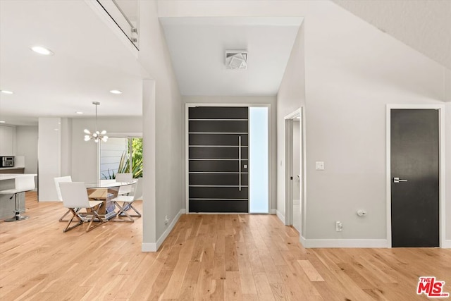 entryway with an inviting chandelier and light wood-type flooring