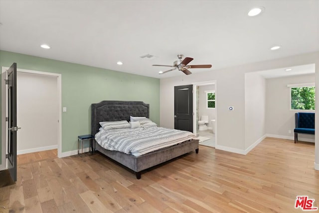 bedroom with ensuite bath, ceiling fan, light hardwood / wood-style flooring, and multiple windows