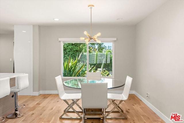 dining space featuring an inviting chandelier and light hardwood / wood-style flooring