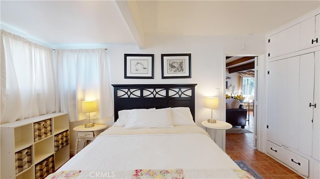 bedroom featuring a closet and beamed ceiling