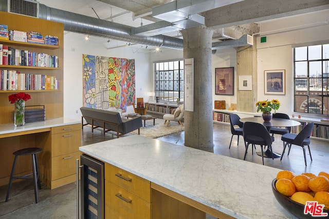 kitchen featuring ornate columns, a wealth of natural light, and wine cooler