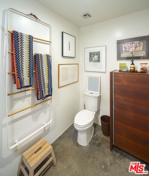 bathroom with concrete flooring and toilet