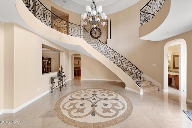 foyer featuring a towering ceiling and an inviting chandelier