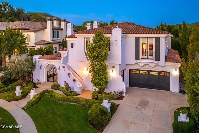 mediterranean / spanish-style home with a yard, a balcony, and a garage