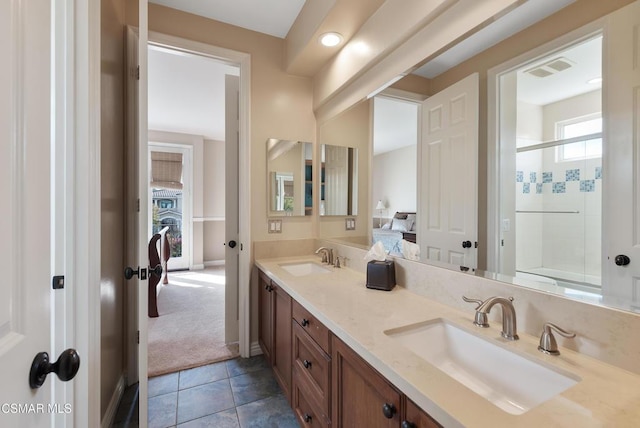 bathroom with vanity, a shower with shower door, and tile patterned floors