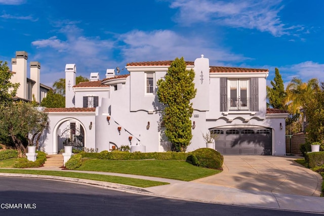 mediterranean / spanish home with a balcony, a front lawn, and a garage