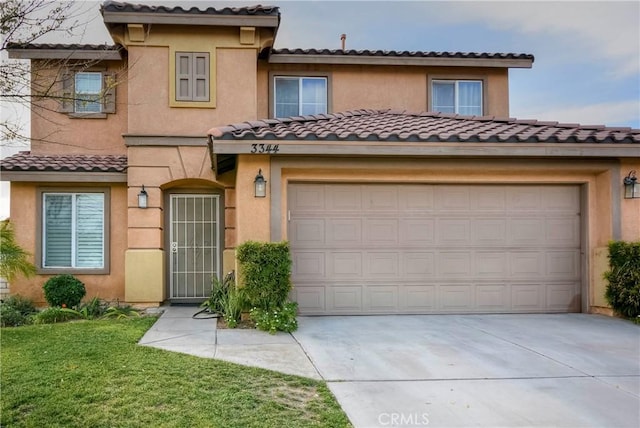 mediterranean / spanish home with a front yard and a garage