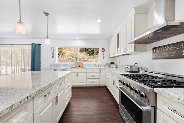 kitchen with a sink, stainless steel appliances, white cabinets, wall chimney range hood, and recessed lighting