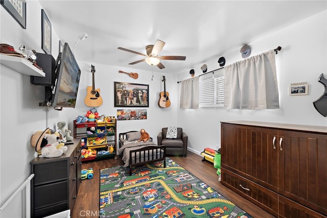 recreation room featuring dark hardwood / wood-style floors and ceiling fan