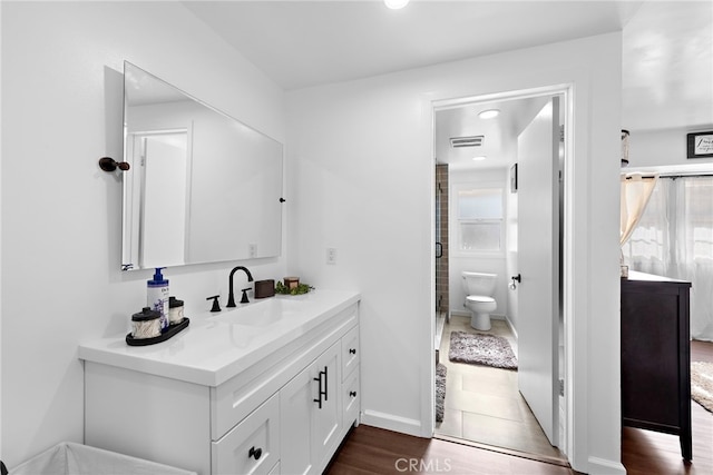 bathroom featuring vanity, hardwood / wood-style flooring, and toilet