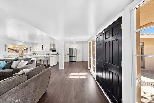 living room with a wealth of natural light, dark wood finished floors, and recessed lighting