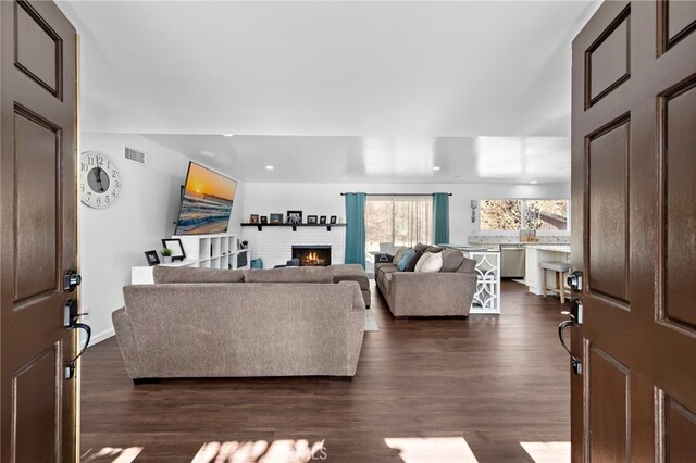 living room with dark hardwood / wood-style floors and a fireplace