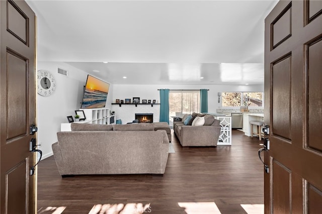 living room featuring dark wood-type flooring and a fireplace