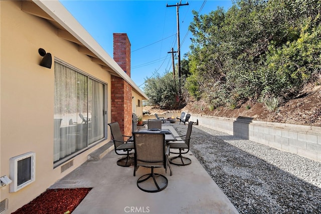 view of patio / terrace with outdoor dining space, visible vents, and heating unit