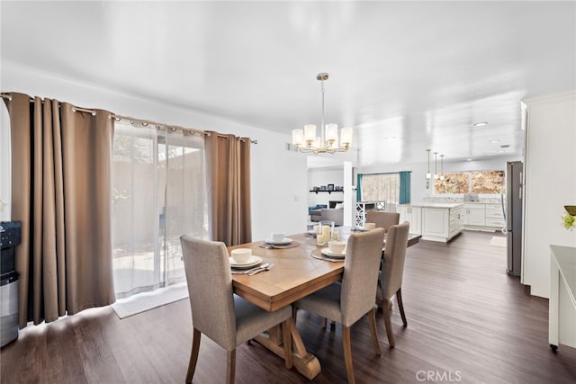 dining space featuring dark wood finished floors and a chandelier