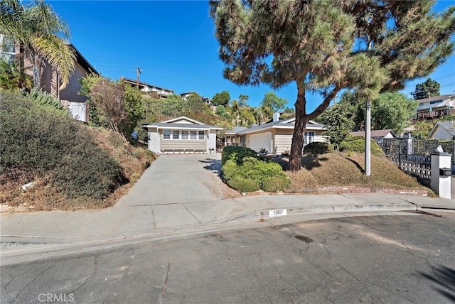 view of front facade featuring concrete driveway and fence