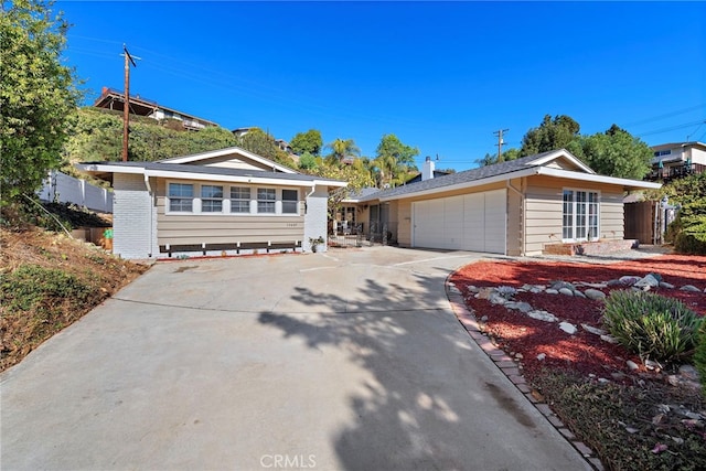 ranch-style home with an attached garage, driveway, and fence