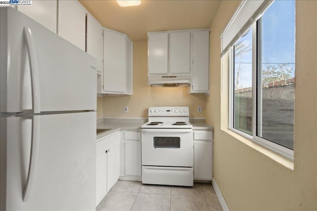 kitchen with white appliances, white cabinetry, and light tile patterned flooring